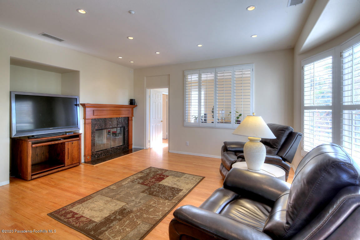 7461 Chanteclair Court Tujunga, CA 91042 - Photo 12 of 44 a living room with furniture a flat screen tv and a fireplace