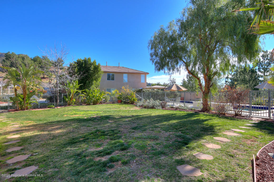 7461 Chanteclair Court Tujunga, CA 91042 - Photo 28 of 44 a view of a backyard with couches under an umbrella