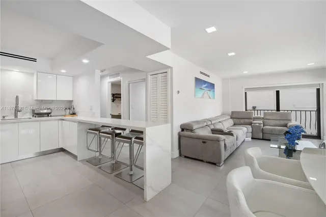 a living room with furniture and view of kitchen