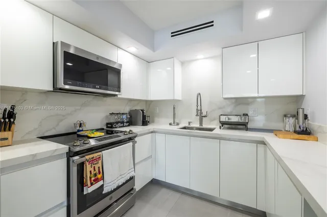 a kitchen with stainless steel appliances granite countertop a sink stove a microwave and cabinets