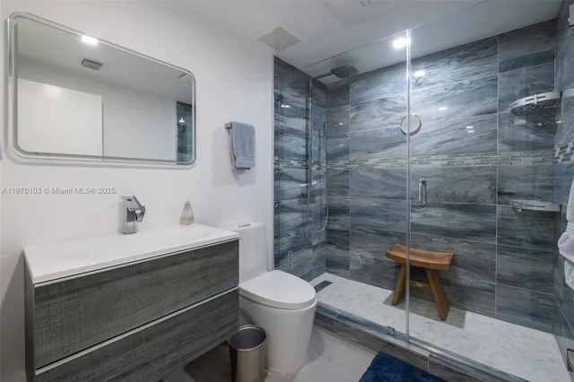 a bathroom with a sink toilet a mirror and shower