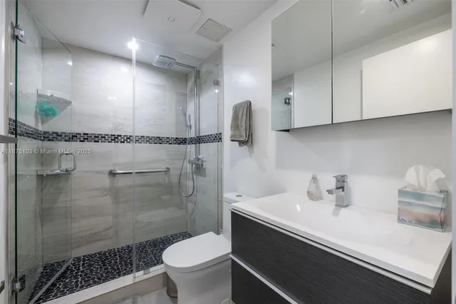 a bathroom with a sink a toilet and shower