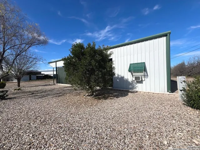 a backyard of a house with fountain table and chairs