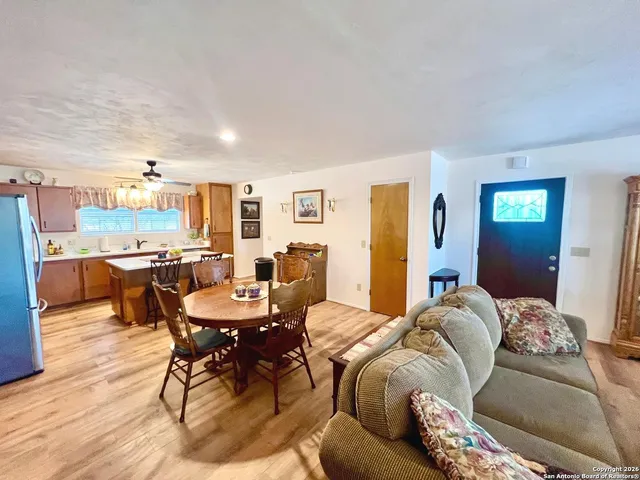 a kitchen with stainless steel appliances a table chairs and a refrigerator