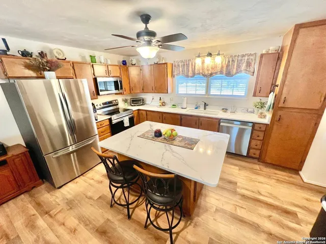 a large kitchen with stainless steel appliances granite countertop a stove a sink dishwasher and a stove with wooden floor