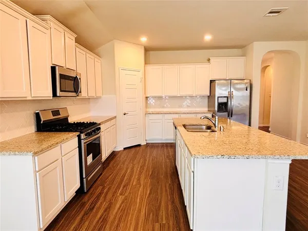 a kitchen with a sink stove and refrigerator