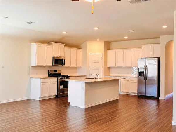 a kitchen with stainless steel appliances a refrigerator sink and stove top oven