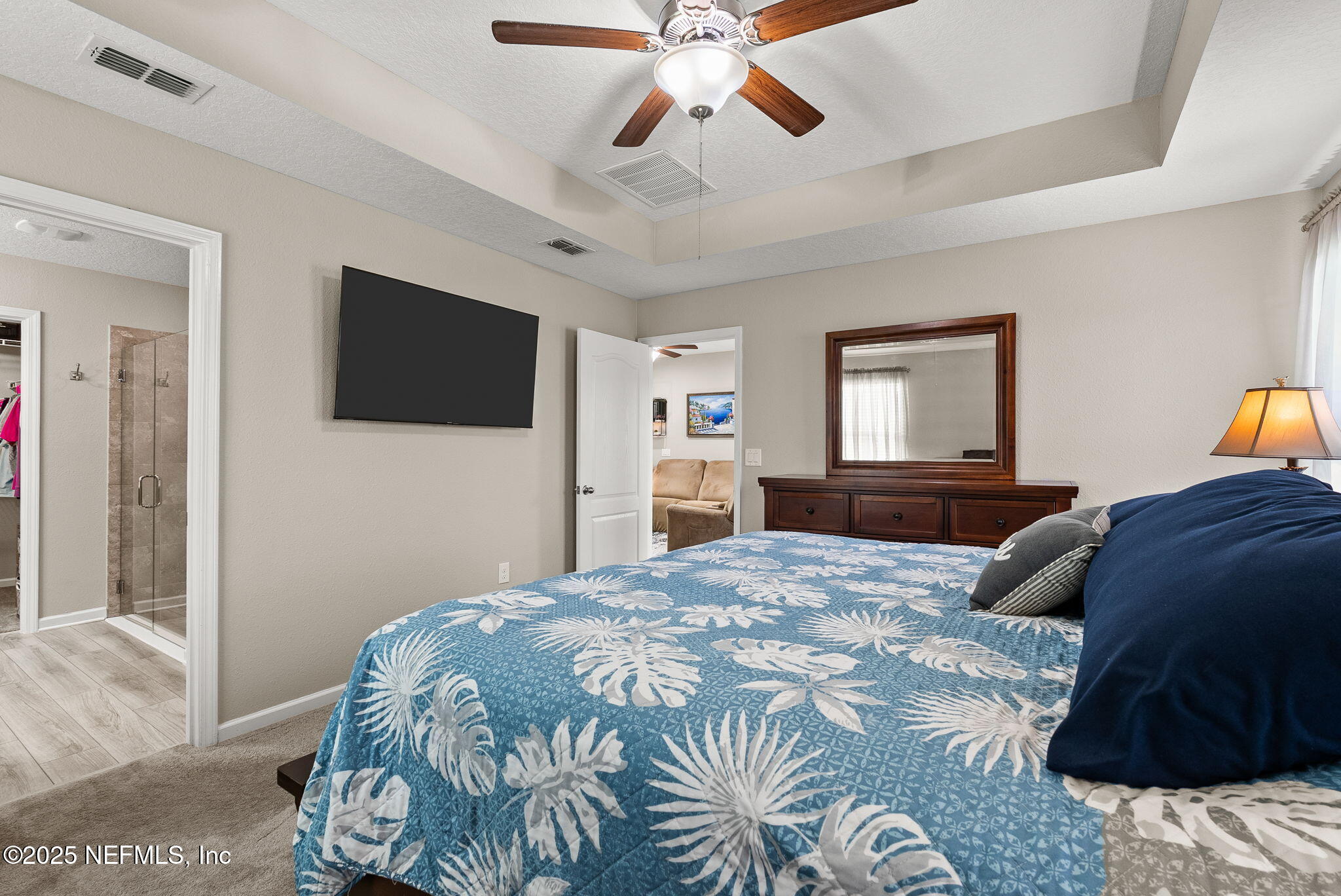 3961 Heatherbrook Place Middleburg, FL 32068 - Photo 11 of 28 a bedroom with a large bed and a flat screen tv