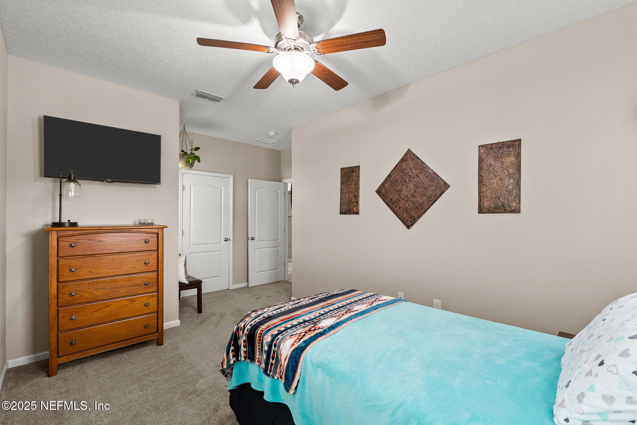 3961 Heatherbrook Place Middleburg, FL 32068 - Photo 19 of 28 a bedroom with a bed and a flat screen tv