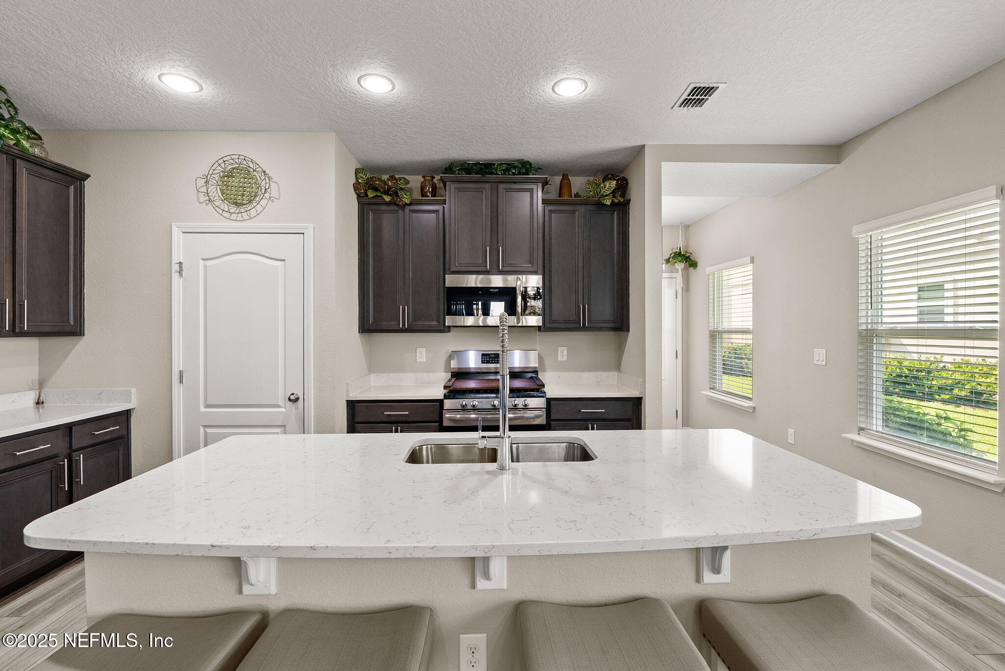 3961 Heatherbrook Place Middleburg, FL 32068 - Photo 7 of 28 a kitchen with kitchen island a sink table and chairs