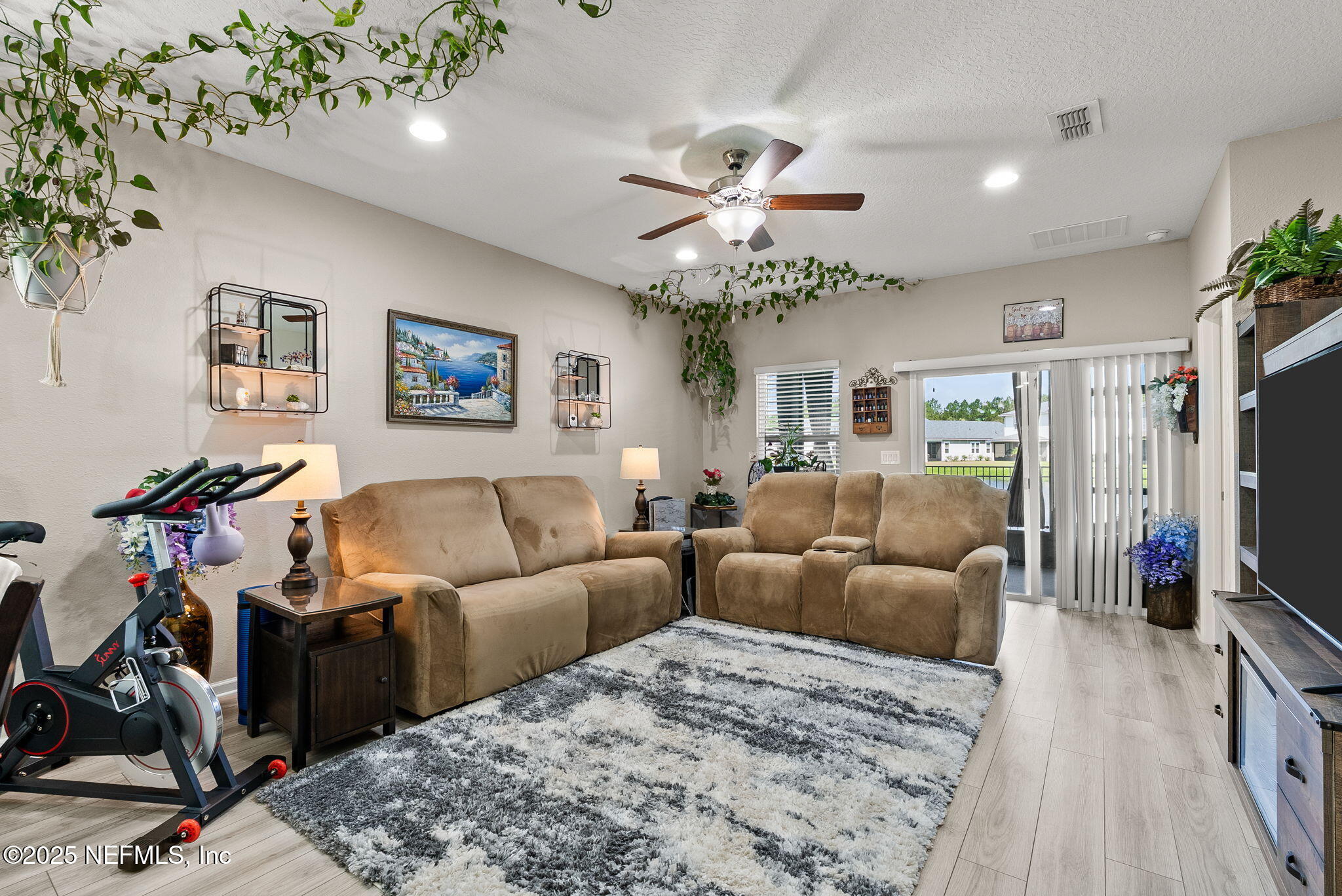 3961 Heatherbrook Place Middleburg, FL 32068 - Photo 8 of 28 a living room with furniture a flat screen tv and a chandelier