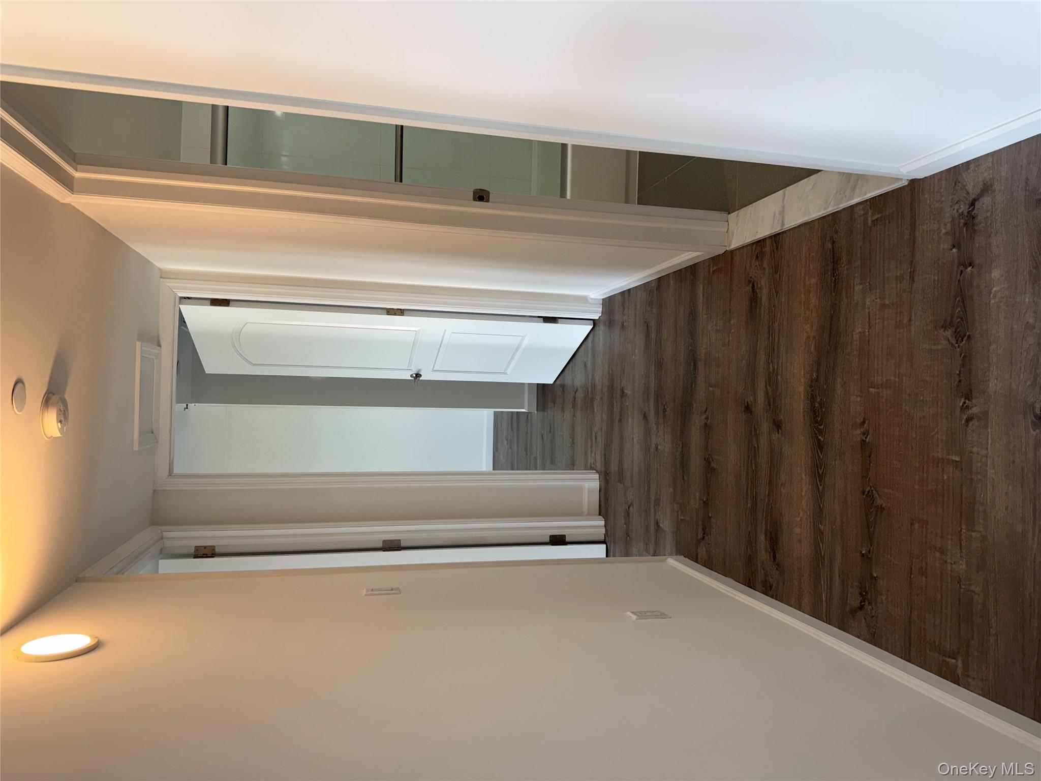 214-10 15th Avenue, Unit 3D & P6 Queens, NY 11360 - Photo 11 of 13 a view of a hallway with wooden floor and staircase