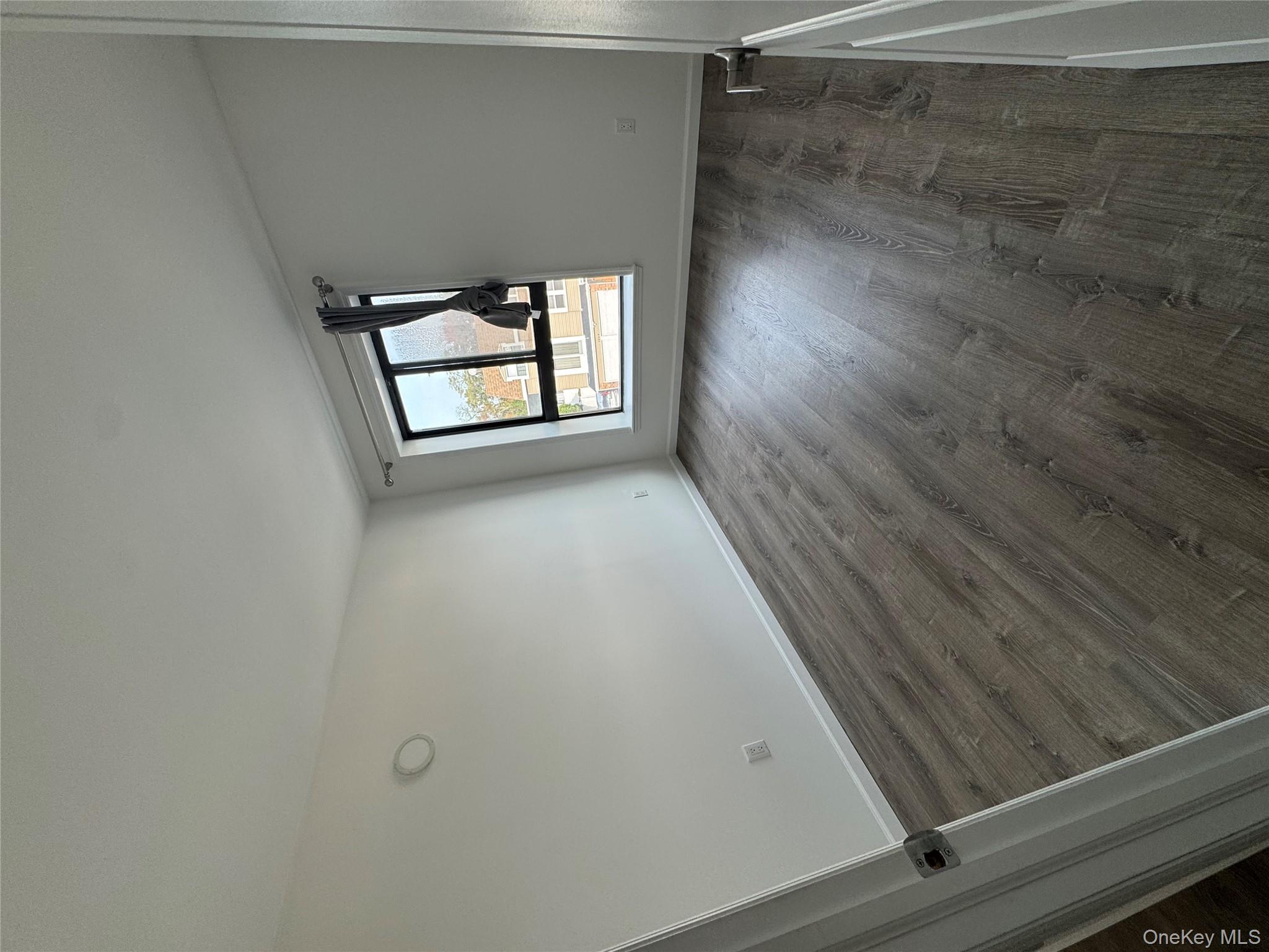 214-10 15th Avenue, Unit 3D & P6 Queens, NY 11360 - Photo 4 of 13 an empty room with wooden floor and windows