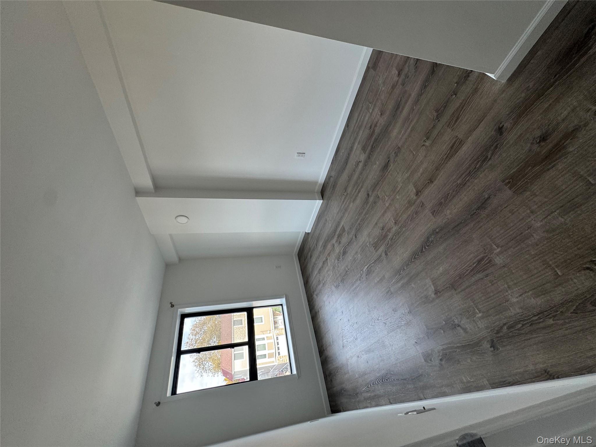 214-10 15th Avenue, Unit 3D & P6 Queens, NY 11360 - Photo 5 of 13 an empty room with wooden floor and windows