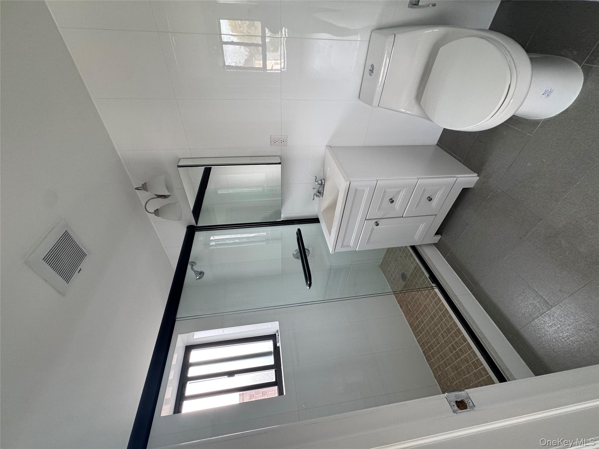 214-10 15th Avenue, Unit 3D & P6 Queens, NY 11360 - Photo 8 of 13 a bathroom with a toilet sink and mirror