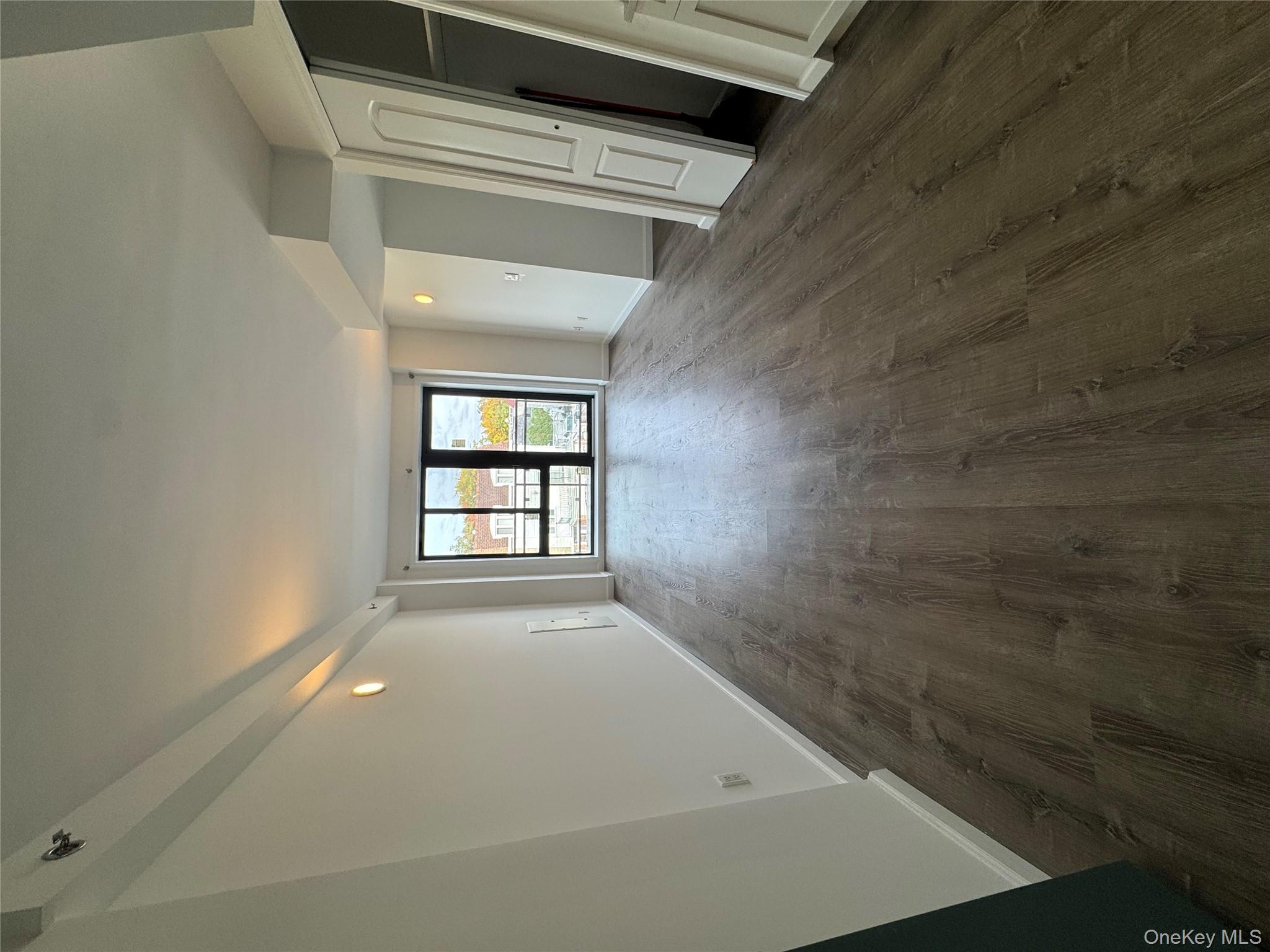 214-10 15th Avenue, Unit 3D & P6 Queens, NY 11360 - Photo 9 of 13 an empty room with wooden floor and windows