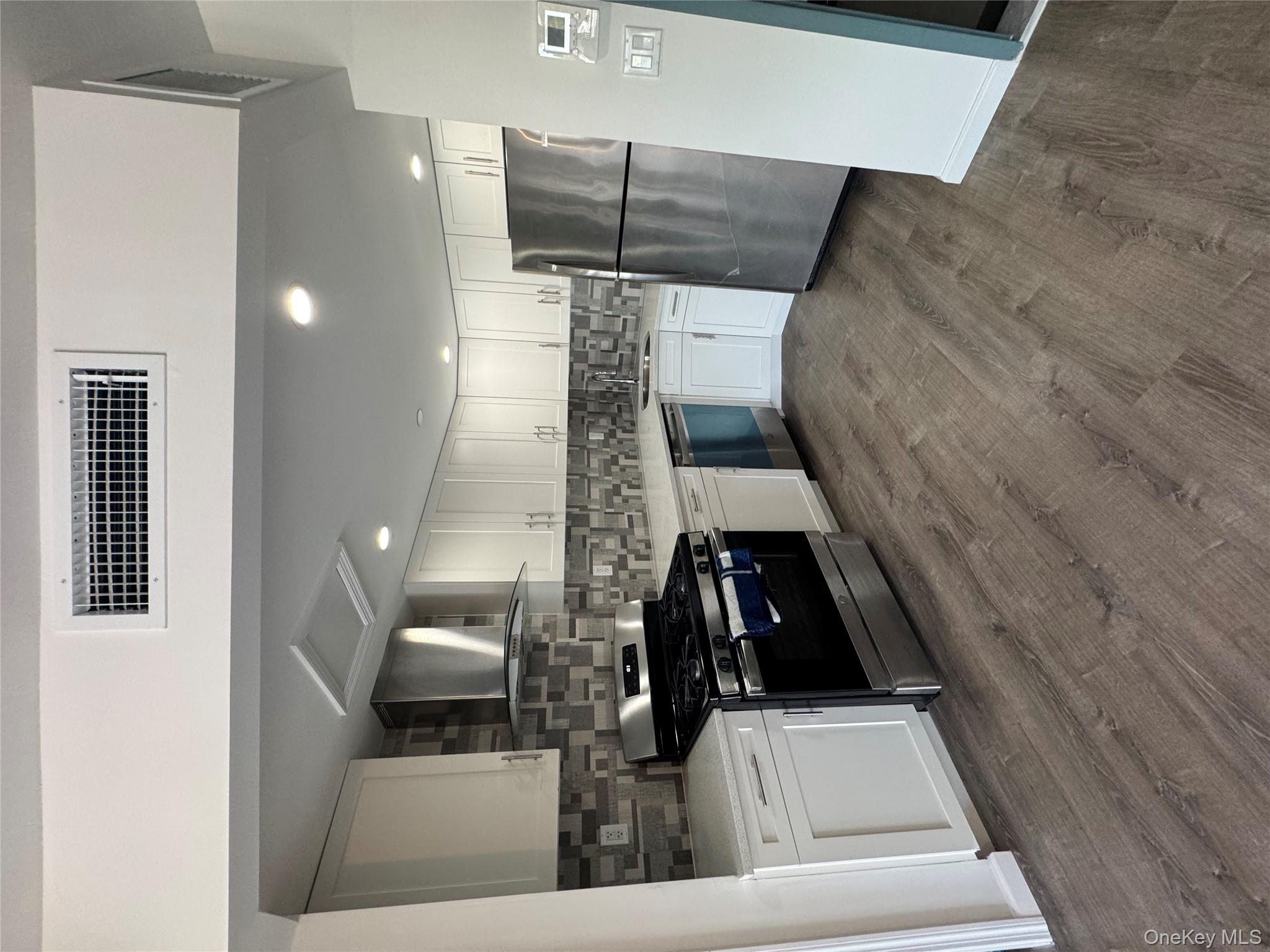 214-10 15th Avenue, Unit 3D & P6 Queens, NY 11360 - Photo 10 of 13 a large kitchen with a stove and a refrigerator