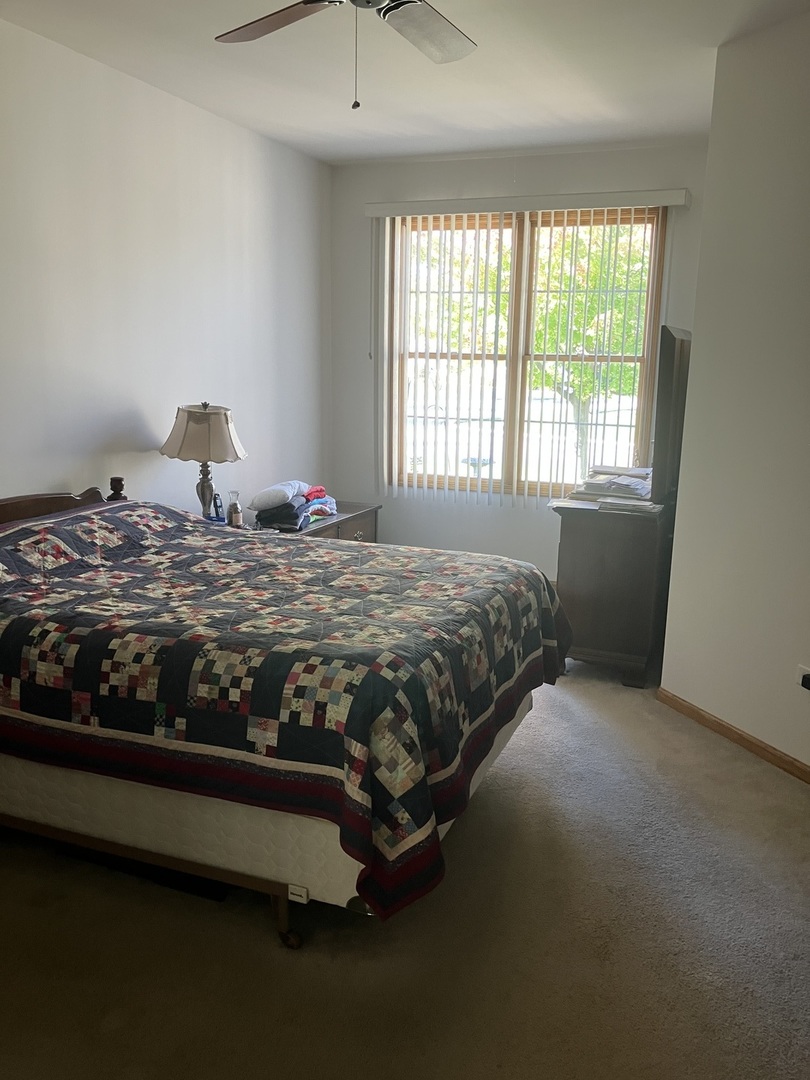19246 104th Avenue Mokena, IL 60448 - Photo 14 of 38 a bed sitting in a bedroom next to a window