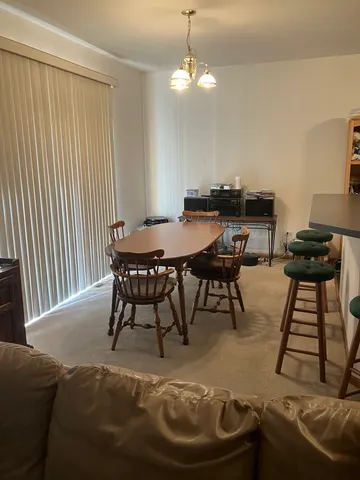 a kitchen with stainless steel appliances granite countertop a table chairs sink and cabinets
