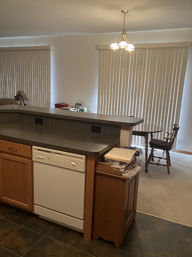 19246 104th Avenue Mokena, IL 60448 - Photo 24 of 38 a kitchen with granite countertop a sink a stove and a wooden cabinets