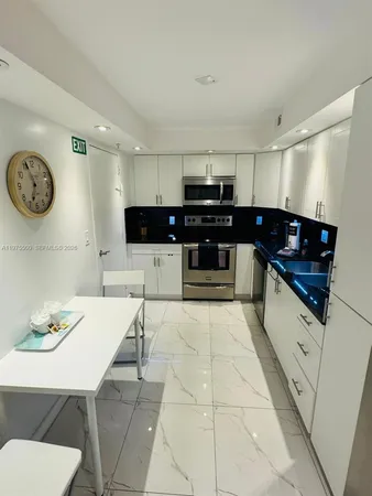 a kitchen with stainless steel appliances a stove a sink and a refrigerator