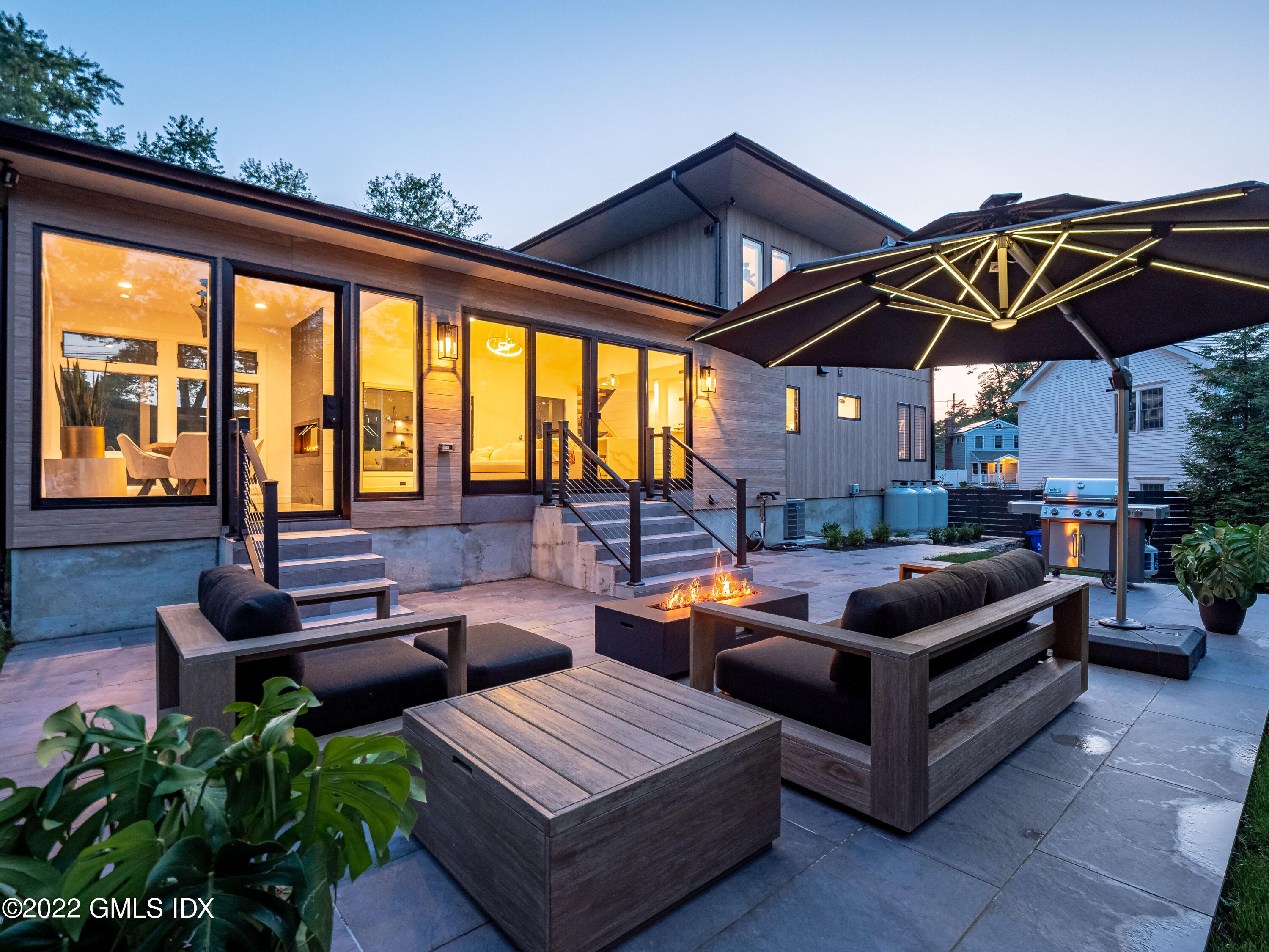 7 Drumlin Road Westport, CT 06880 - Photo 24 of 32 a view of a patio with couches and chairs under an umbrella