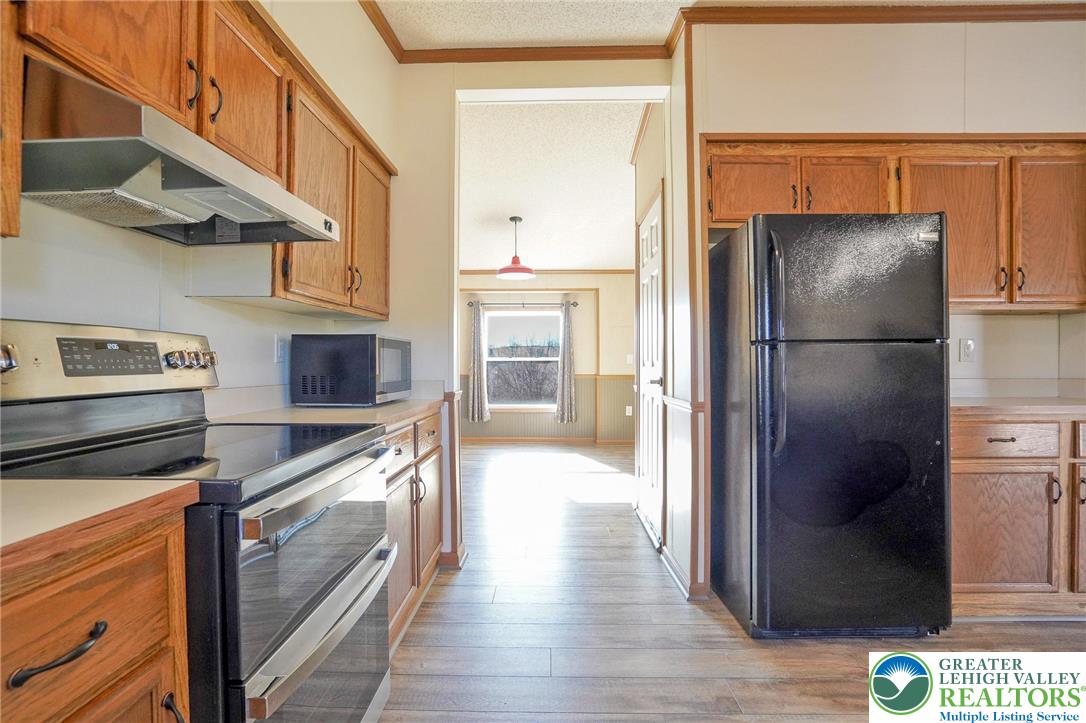 7221 Borman Road New Tripoli, PA 18066 - Photo 22 of 62 a kitchen with stainless steel appliances granite countertop a refrigerator a stove and a sink with wooden floor