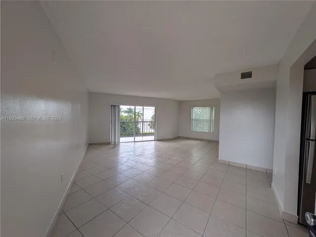 an empty room with windows and cabinet
