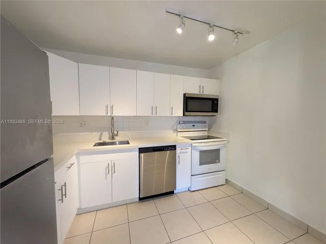 a kitchen with a stove sink and cabinets