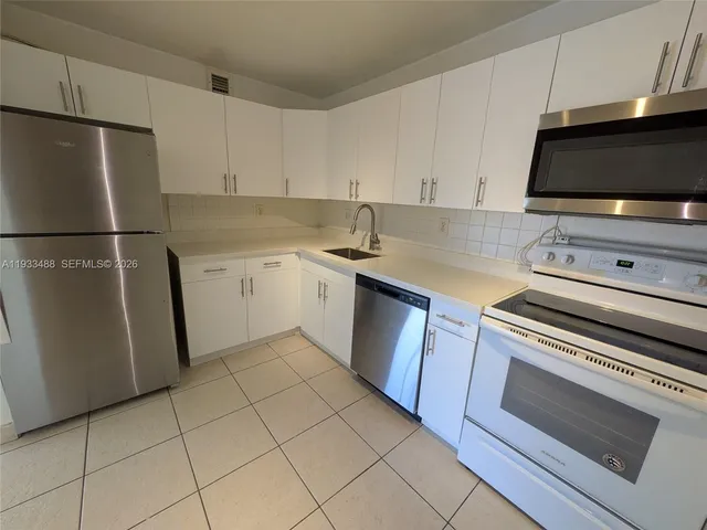 a kitchen with sink a microwave and refrigerator