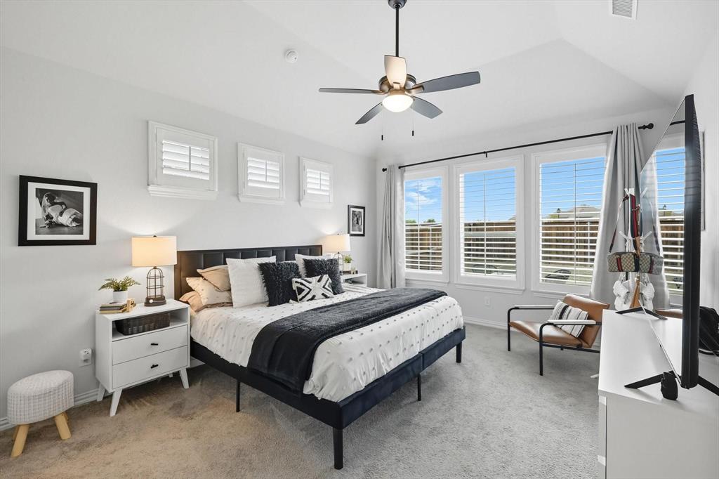 1724 Wassel Road Fort Worth, TX 76052 - Photo 13 of 24 Carpeted bedroom featuring a vaulted ceiling with a flush-mount ceiling fan, three large windows with white louvered blinds, and three smaller square windows with white louvered shutters