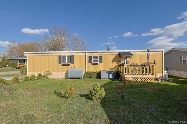 a view of a house with a big yard and a large tree