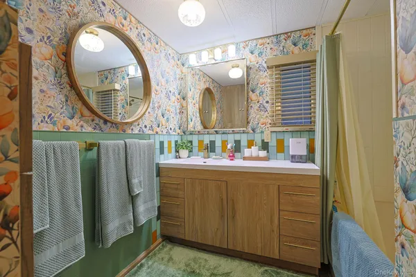 a bathroom with a sink mirror and a shower