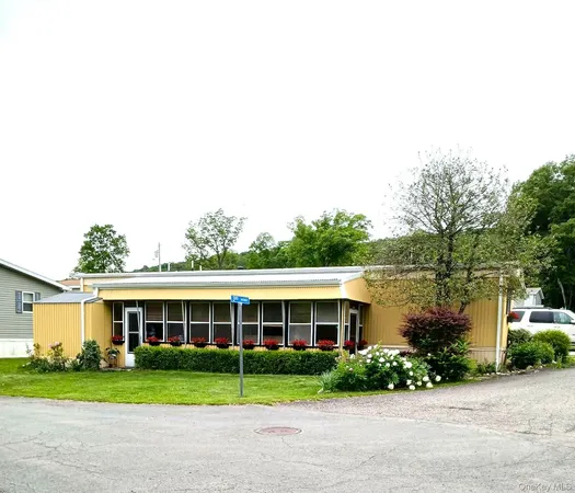 a front view of a house with a yard and potted plants