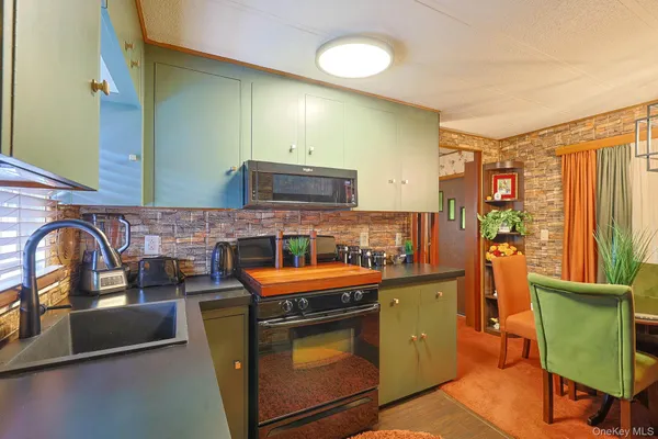 a kitchen with stainless steel appliances granite countertop a stove a sink dishwasher and cabinets with wooden floor