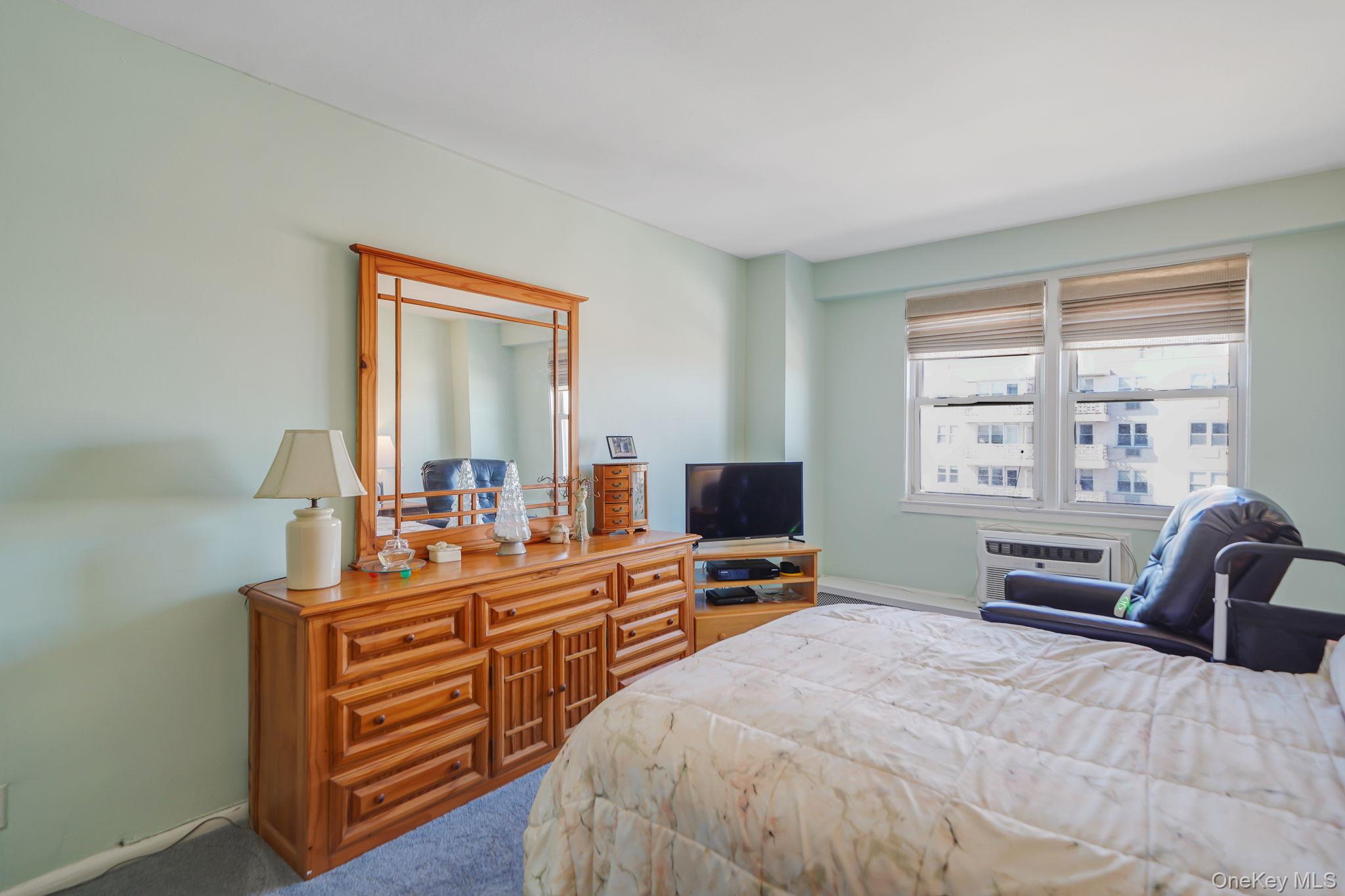 450 Shore Road, Unit 8G Long Beach, NY 11561 - Photo 11 of 19 a bedroom with furniture and a flat screen tv