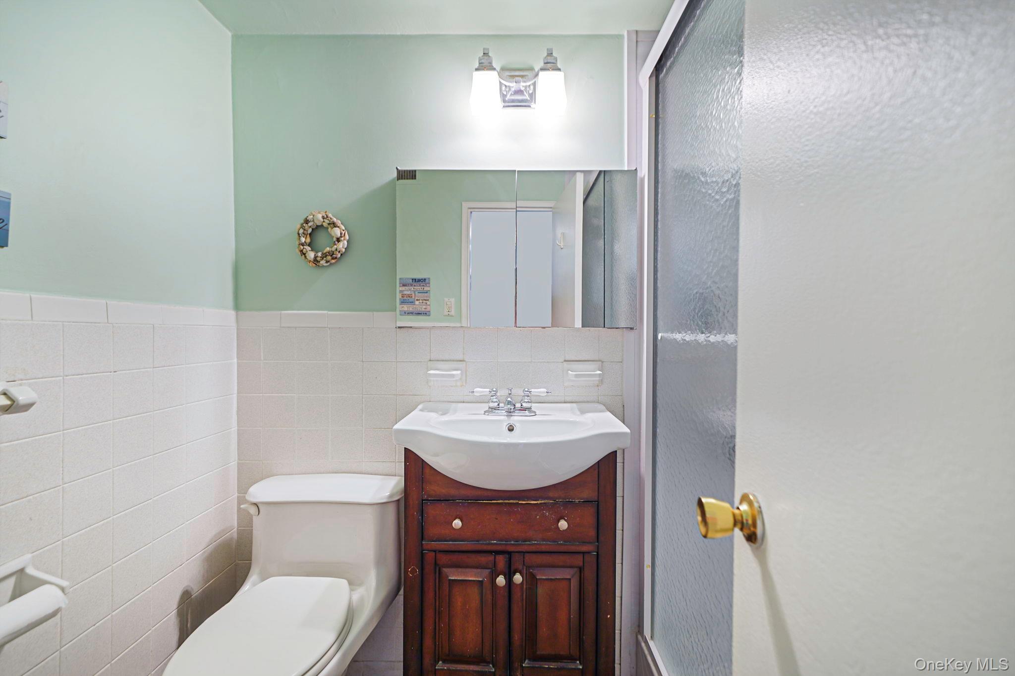 450 Shore Road, Unit 8G Long Beach, NY 11561 - Photo 14 of 19 a bathroom with a sink a toilet and mirror