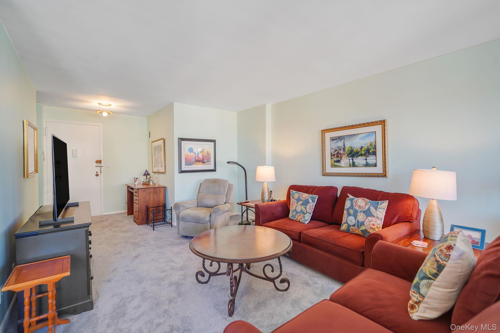 450 Shore Road, Unit 8G Long Beach, NY 11561 - Photo 6 of 19 a living room with furniture a rug and a flat screen tv