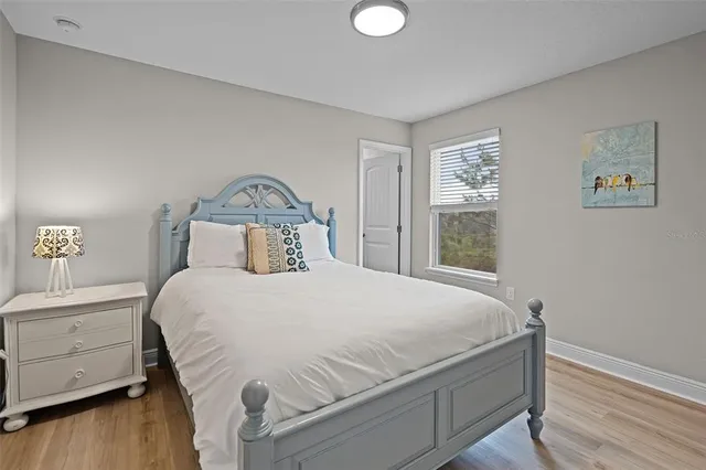 a bedroom with a bed and wooden floor