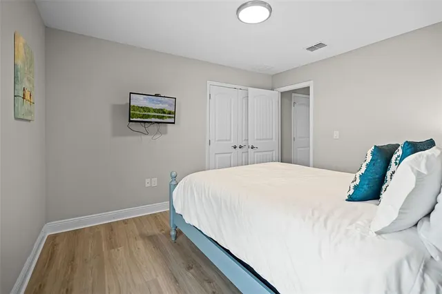 a bedroom with a bed and a wooden floor