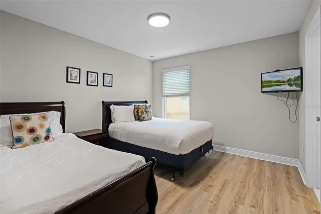 a bedroom with two beds and a lamp