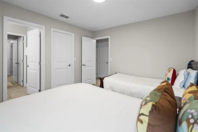 a bedroom with two beds and a lamp