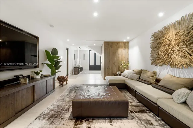 a kitchen with stainless steel appliances a dining table chairs and refrigerator