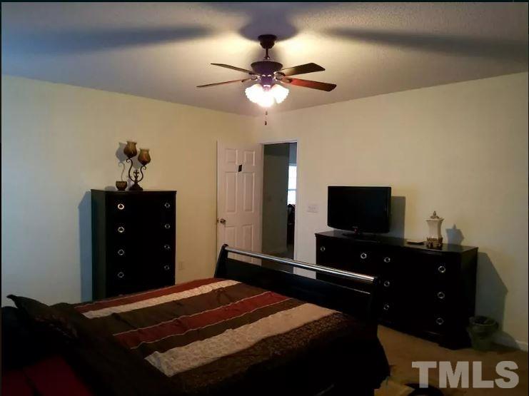 5956 Ricker Road Raleigh, NC 27610 - Photo 8 of 13 a bedroom with a bed and a flat screen tv