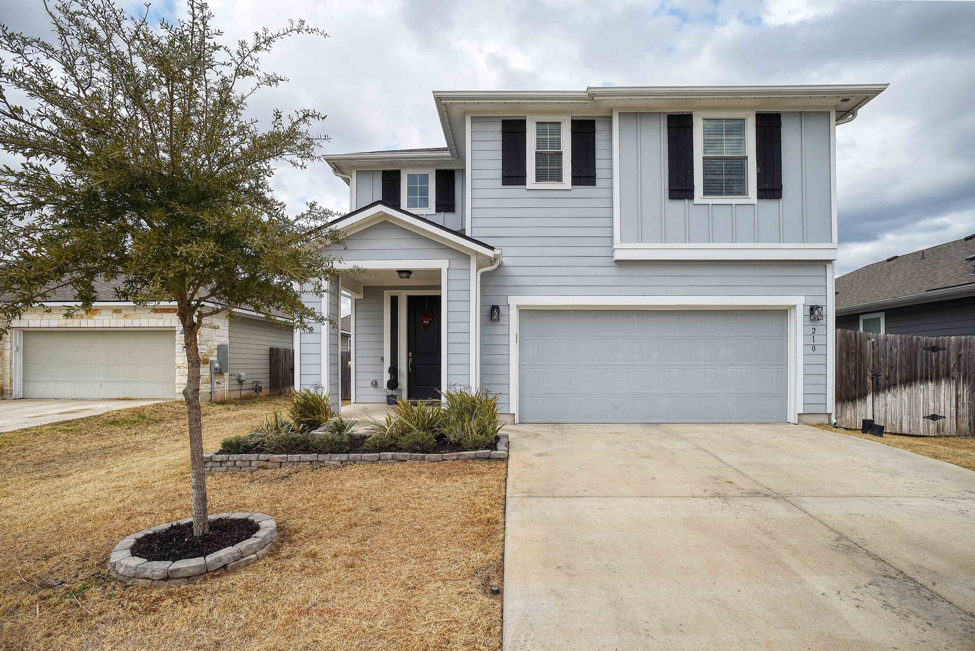 View of front of house with concrete driveway, an attached garage, and board and batten siding