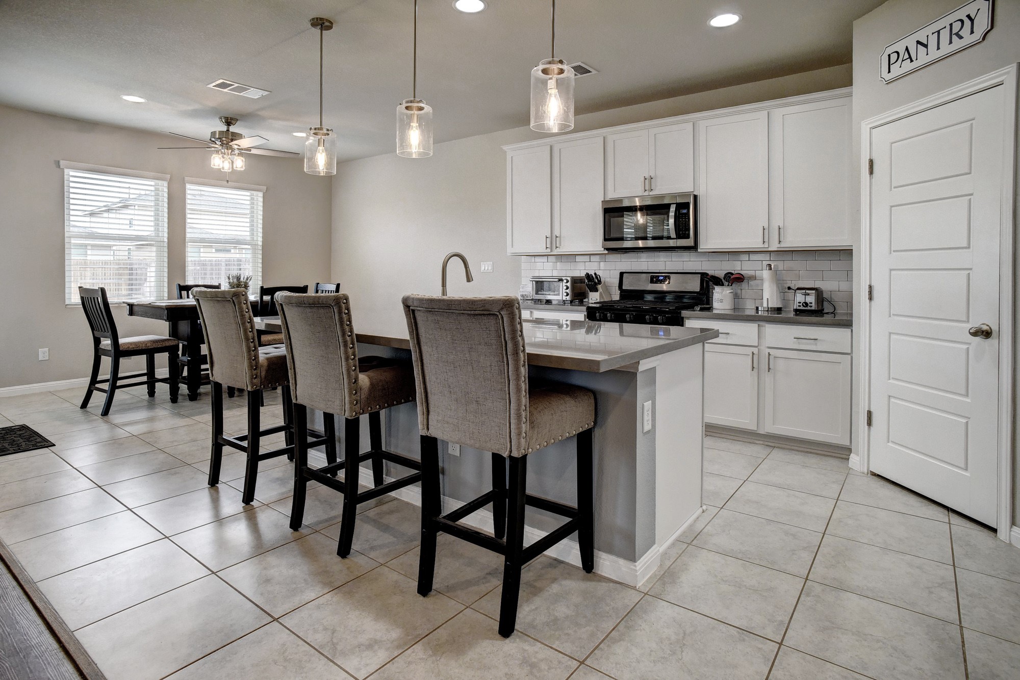 210 Cold Spg Loop Bastrop, TX 78602 - Photo 15 of 40 Kitchen featuring an island with sink, pendant lighting, a breakfast bar, and white cabinetry
