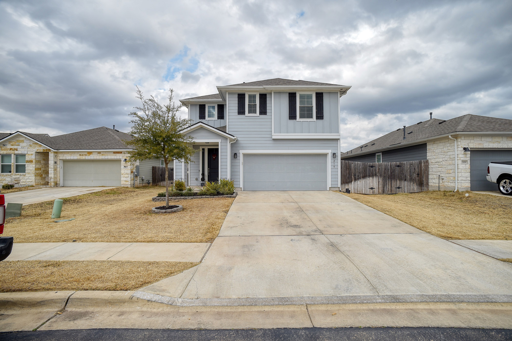 210 Cold Spg Loop Bastrop, TX 78602 - Photo 2 of 40 Traditional home featuring driveway, an attached garage, and board and batten siding