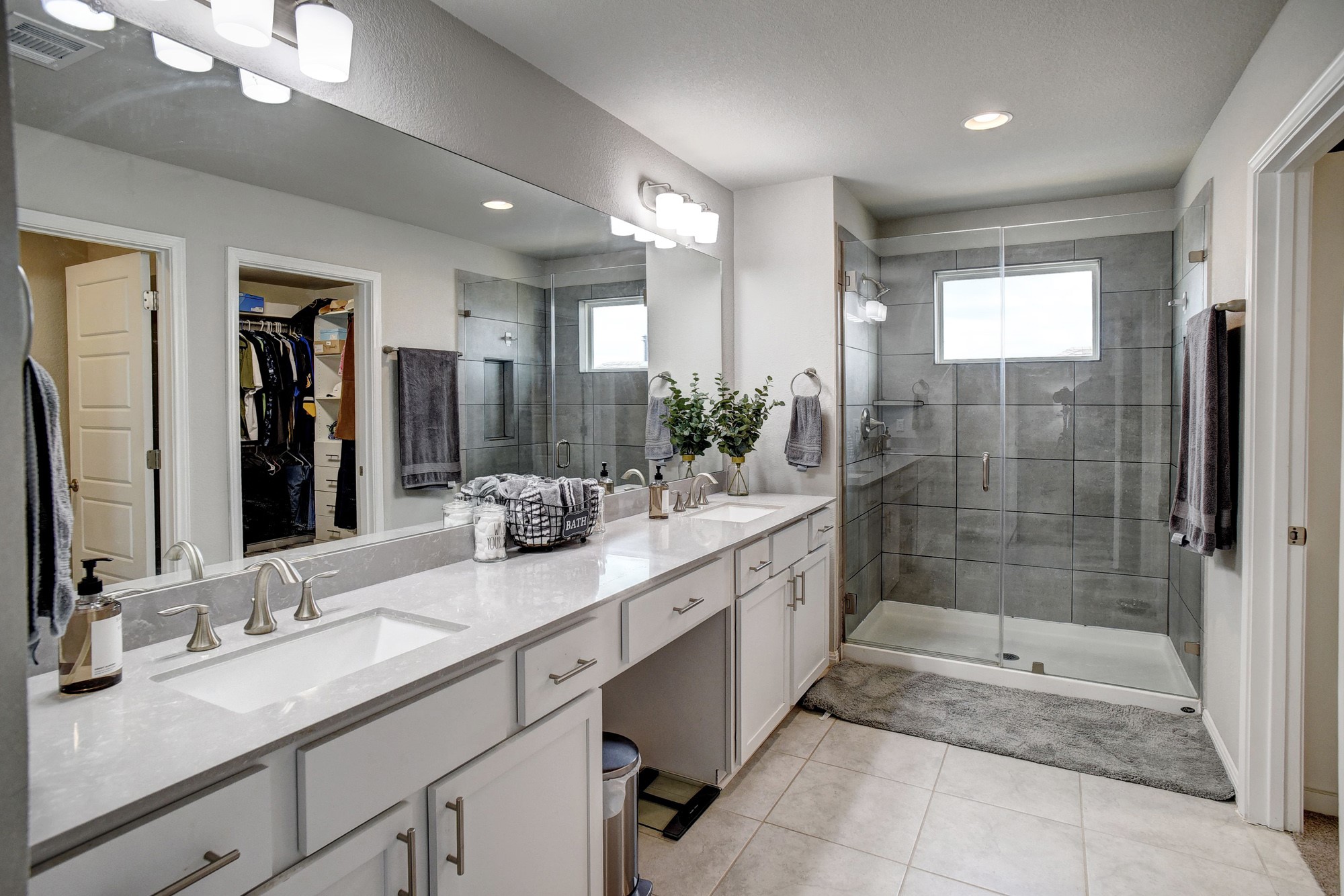 210 Cold Spg Loop Bastrop, TX 78602 - Photo 28 of 40 Full bath with double vanity, a spacious closet, a shower stall, and light tile patterned floors