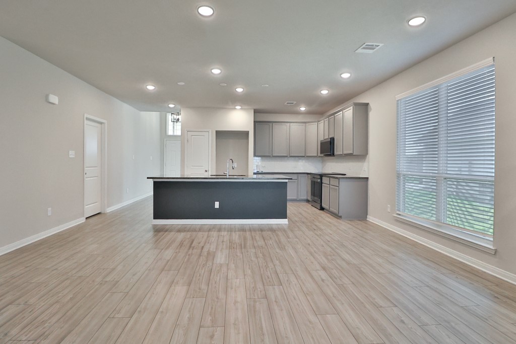 1926 Viva Road Bryan, TX 77807 - Photo 17 of 39 a open kitchen with kitchen island a sink dishwasher stove and wooden floors
