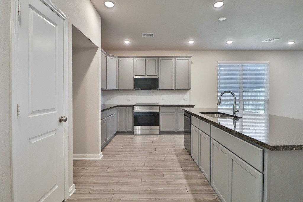 1926 Viva Road Bryan, TX 77807 - Photo 7 of 39 a large kitchen with stainless steel appliances granite countertop a sink and cabinets